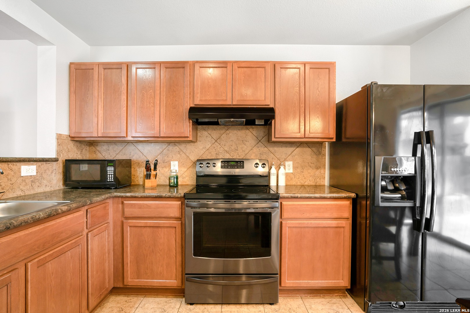 2306 Howry Drive Georgetown, TX 78626 - Photo 6 of 15 a kitchen with granite countertop a stove top oven cabinetry and stainless steel appliances