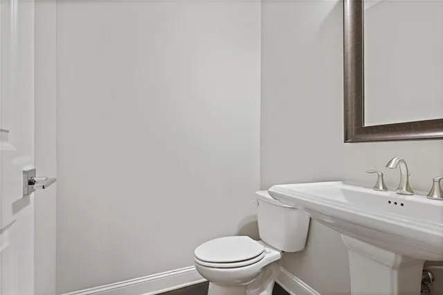 a bathroom with a sink a toilet and a mirror