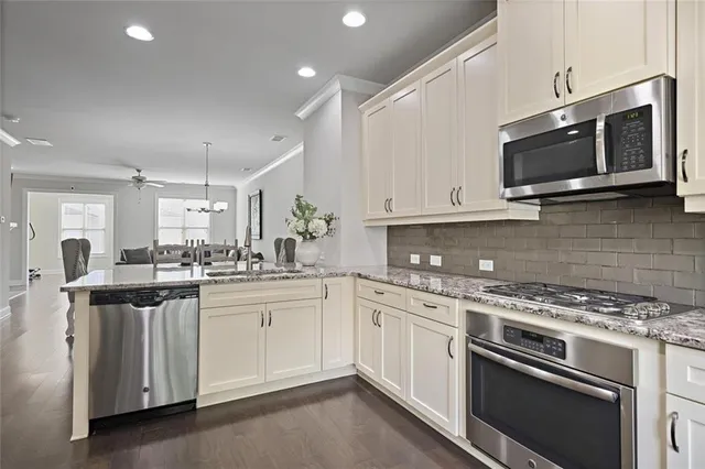 a kitchen with stainless steel appliances granite countertop a stove top oven microwave and cabinets