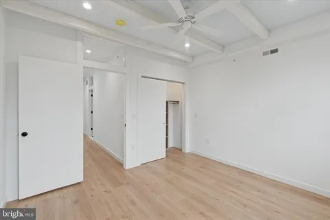 wooden floor in an empty room with a ceiling fan