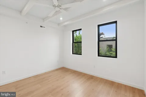 an empty room with windows and closet