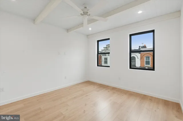 an empty room with windows and fan