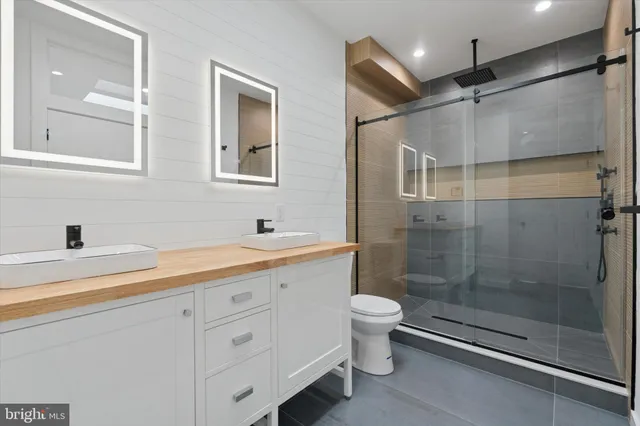a bathroom with a double vanity sink toilet and shower