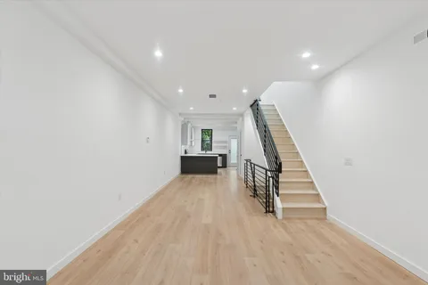 a view of a livingroom with wooden floor and stairs