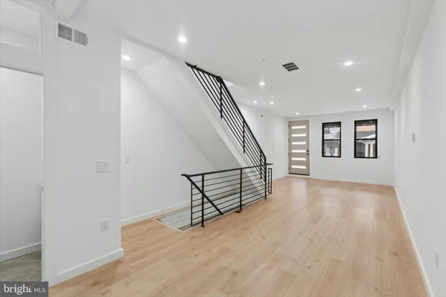 an empty room with wooden floor and white walls