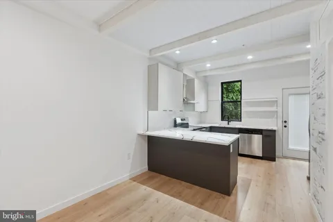 a kitchen with a sink cabinets and wooden floor