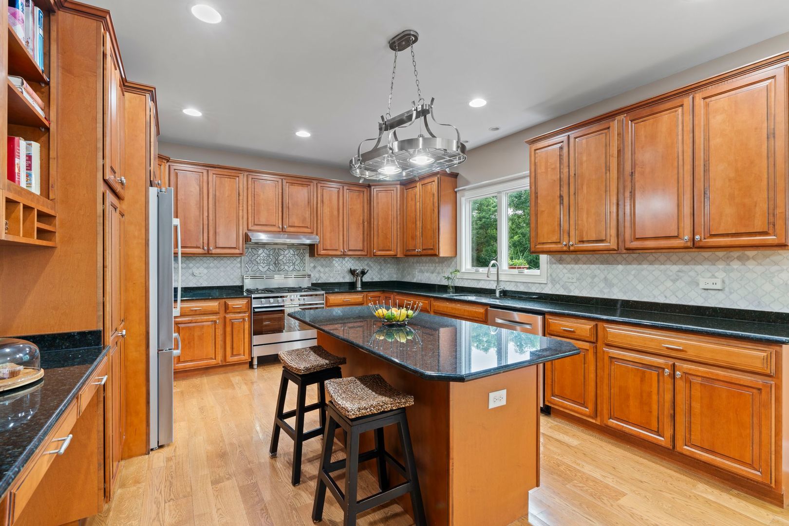 106 Forest View Drive Lake Bluff, IL 60044 - Photo 12 of 56 a kitchen with stainless steel appliances granite countertop wooden cabinets a center island and a window