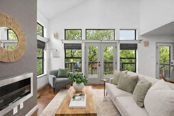 a living room with furniture large window and a fireplace