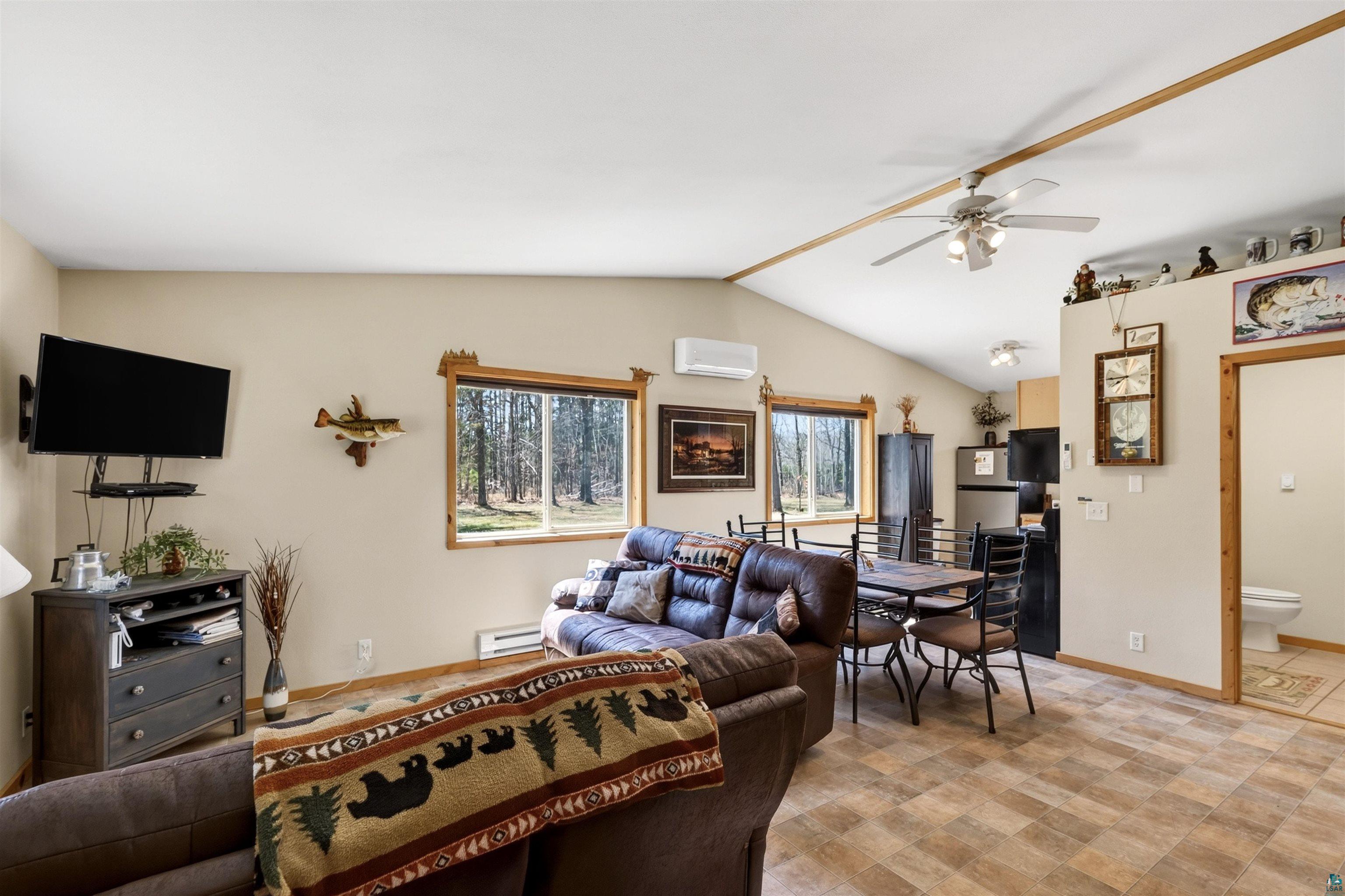 12235 East Crooked Lake Road Gordon, WI 54838 - Photo 23 of 48 Open-concept living area featuring vaulted ceilings with exposed wood trim and a ceiling fan