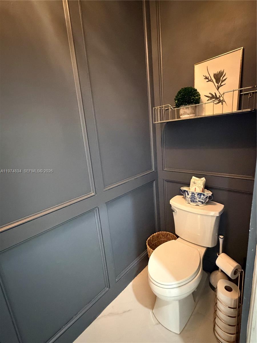 3744 Southwest 156th Court Miami, FL 33185 - Photo 9 of 13 a white toilet sitting next to a wooden floor