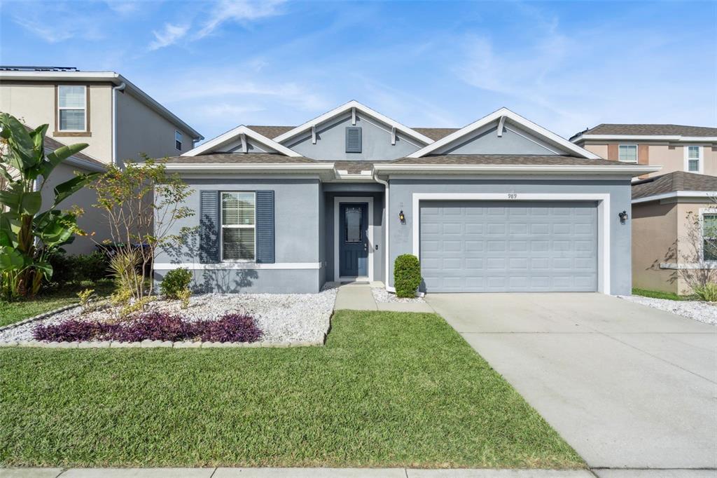 989 Maypole Drive Apopka, FL 32703 - Photo 1 of 39 a front view of a house with a yard and potted plants