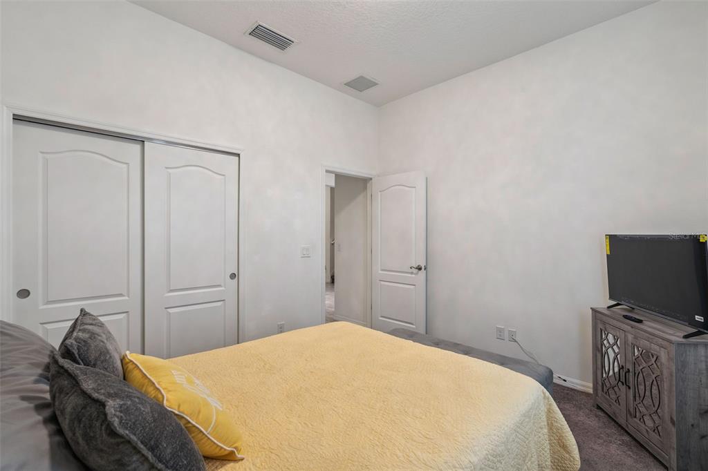 989 Maypole Drive Apopka, FL 32703 - Photo 15 of 39 a bedroom with a bed and a flat screen tv