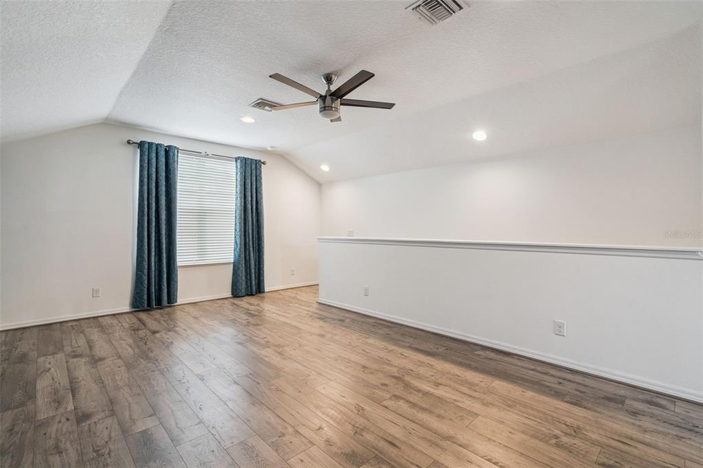 989 Maypole Drive Apopka, FL 32703 - Photo 21 of 39 a view of an empty room with wooden floor and a ceiling fan