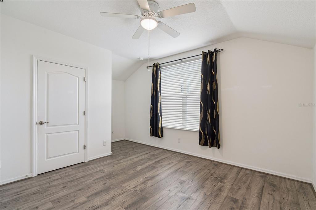 989 Maypole Drive Apopka, FL 32703 - Photo 23 of 39 an empty room with wooden floor chandelier fan and windows