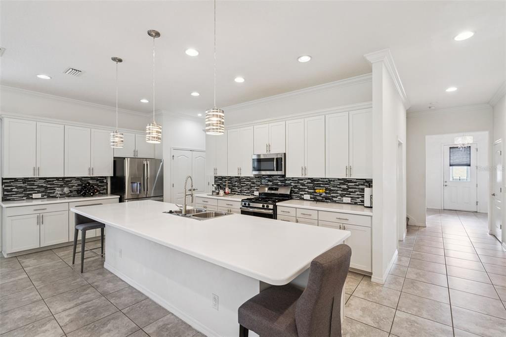 989 Maypole Drive Apopka, FL 32703 - Photo 8 of 39 a kitchen with a sink a stove a refrigerator and white cabinets