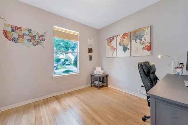 a workspace with wooden floor and a window
