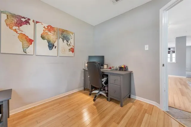 a view of a workspace with furniture and wooden floor
