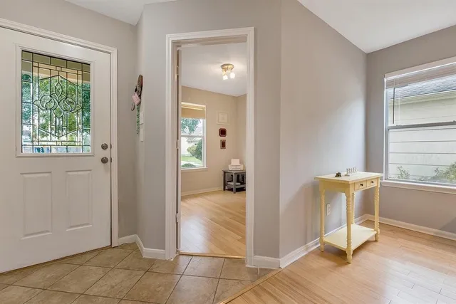 a view of a livingroom with a chair and front door