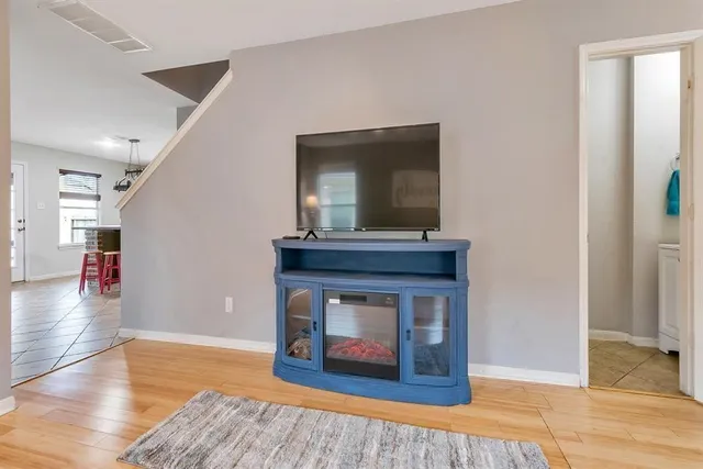 a living room with a fireplace and wooden floor
