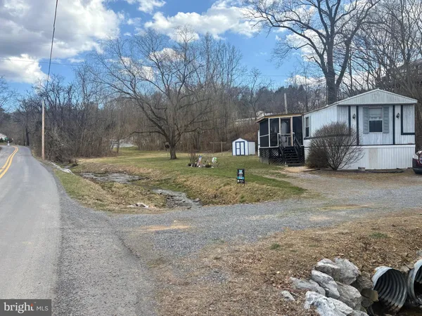 a view of a yard with a house and a tree
