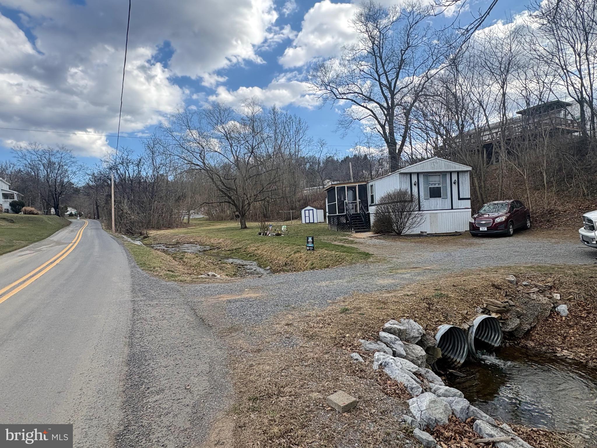 164 Jimtown Road Berkeley Springs, WV 25411 - Photo 4 of 15 a view of a yard with a car parked in front of it