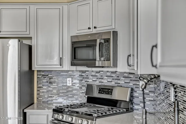 a kitchen with stainless steel appliances granite countertop a refrigerator a stove and a sink