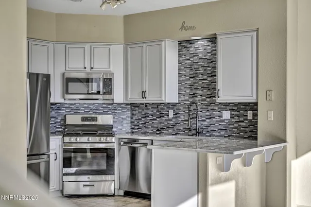 a view of a kitchen with refrigerator and white cabinets