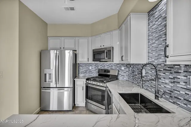 a kitchen with granite countertop a stove top oven and stainless steel appliances