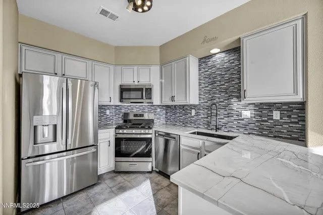 a kitchen with stainless steel appliances granite countertop a sink stove and refrigerator