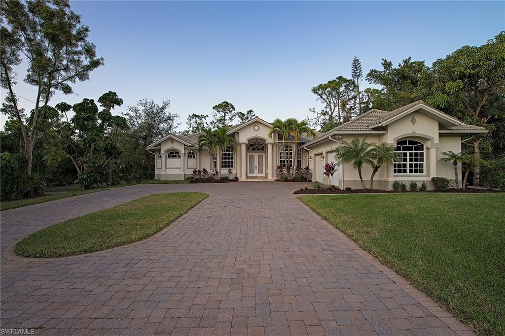 3883 North Road Naples, FL 34104 - Photo 1 of 20 a front view of a house with a yard and trees