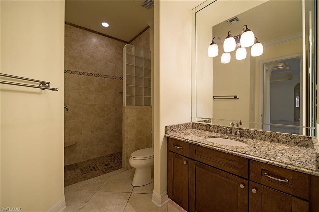 3883 North Road Naples, FL 34104 - Photo 12 of 20 a bathroom with a granite countertop sink mirror and a bathtub