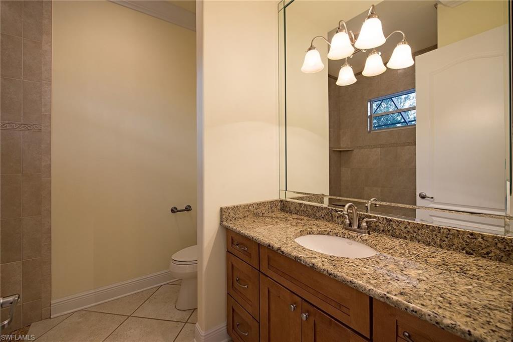 3883 North Road Naples, FL 34104 - Photo 14 of 20 a bathroom with a granite countertop sink and a mirror