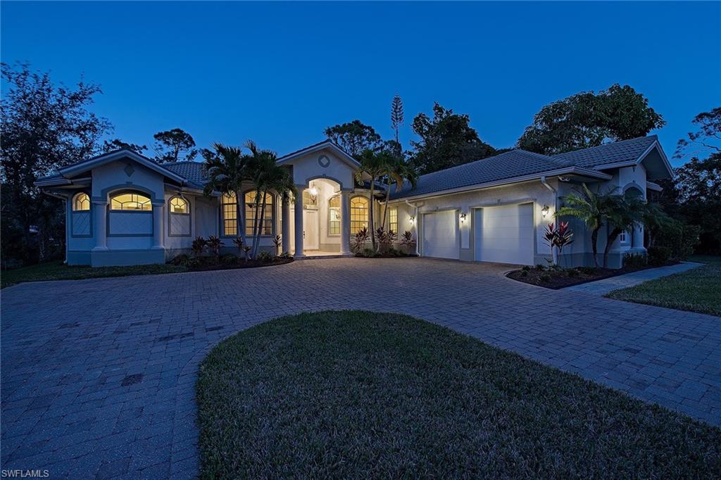3883 North Road Naples, FL 34104 - Photo 17 of 20 a front view of a house with a yard and garage