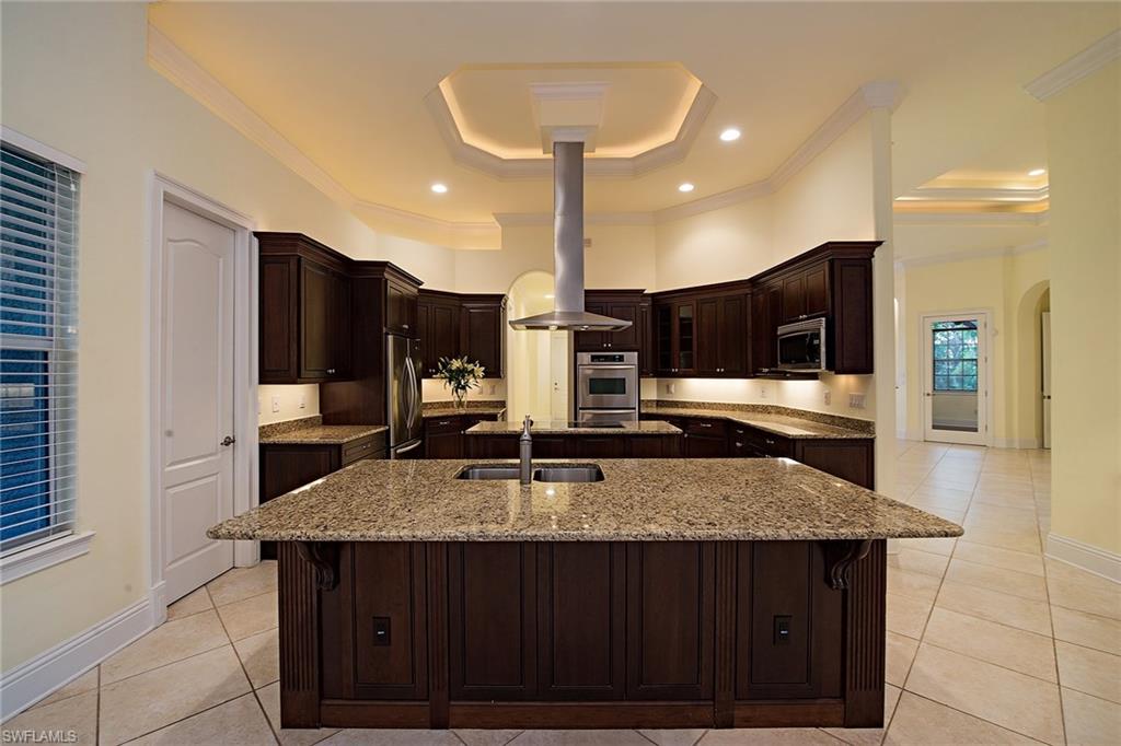 3883 North Road Naples, FL 34104 - Photo 6 of 20 a kitchen with kitchen island granite countertop wooden cabinets and a granite counter tops