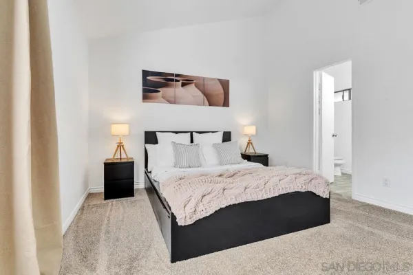 a bedroom with a bed and a painting on the wall