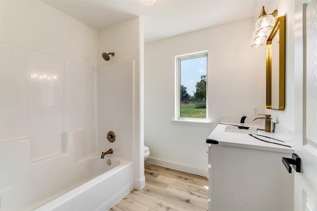 306 Sunset Street Roxton, TX 75477 - Photo 18 of 26 a bathroom with a sink and a bathtub