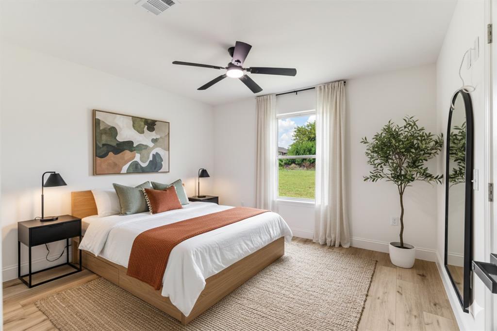 306 Sunset Street Roxton, TX 75477 - Photo 20 of 26 a bedroom with a large bed and a chandelier