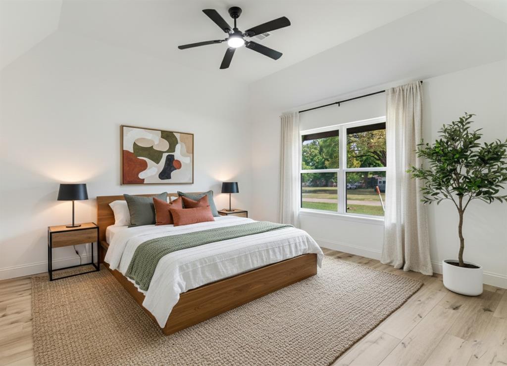 306 Sunset Street Roxton, TX 75477 - Photo 8 of 26 a spacious bedroom with a large bed and a potted plant