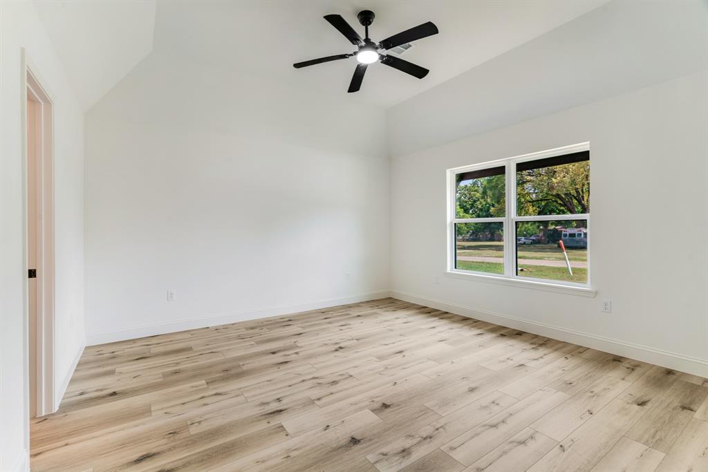 306 Sunset Street Roxton, TX 75477 - Photo 9 of 26 a view of a room with wooden floor and a window
