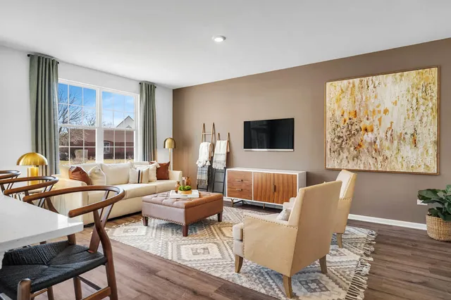 a living room with furniture a flat screen tv and a large window