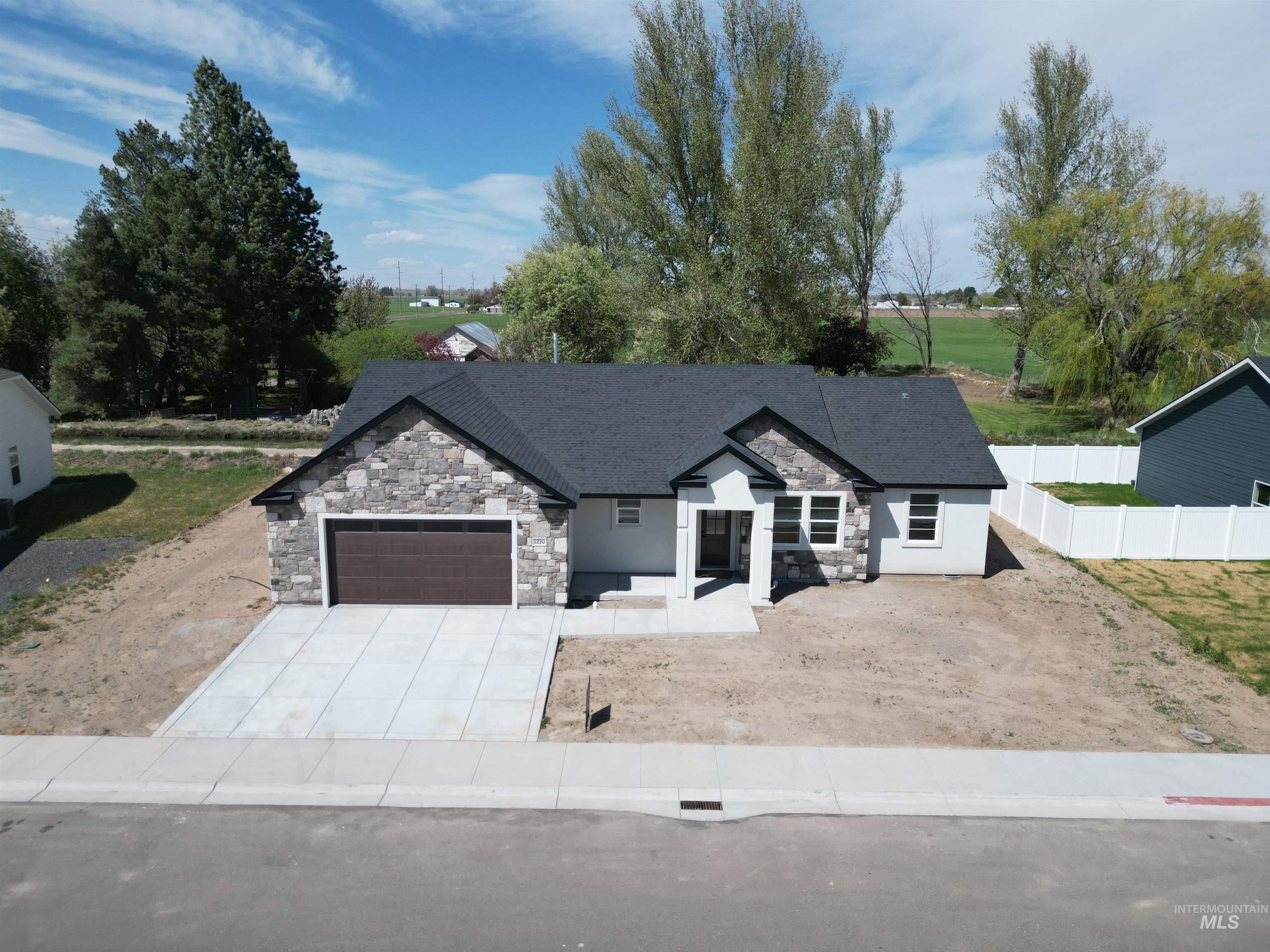 Contemporary single-story residence with a dark shingle roof and a stone veneer facade accenting the garage and front entry