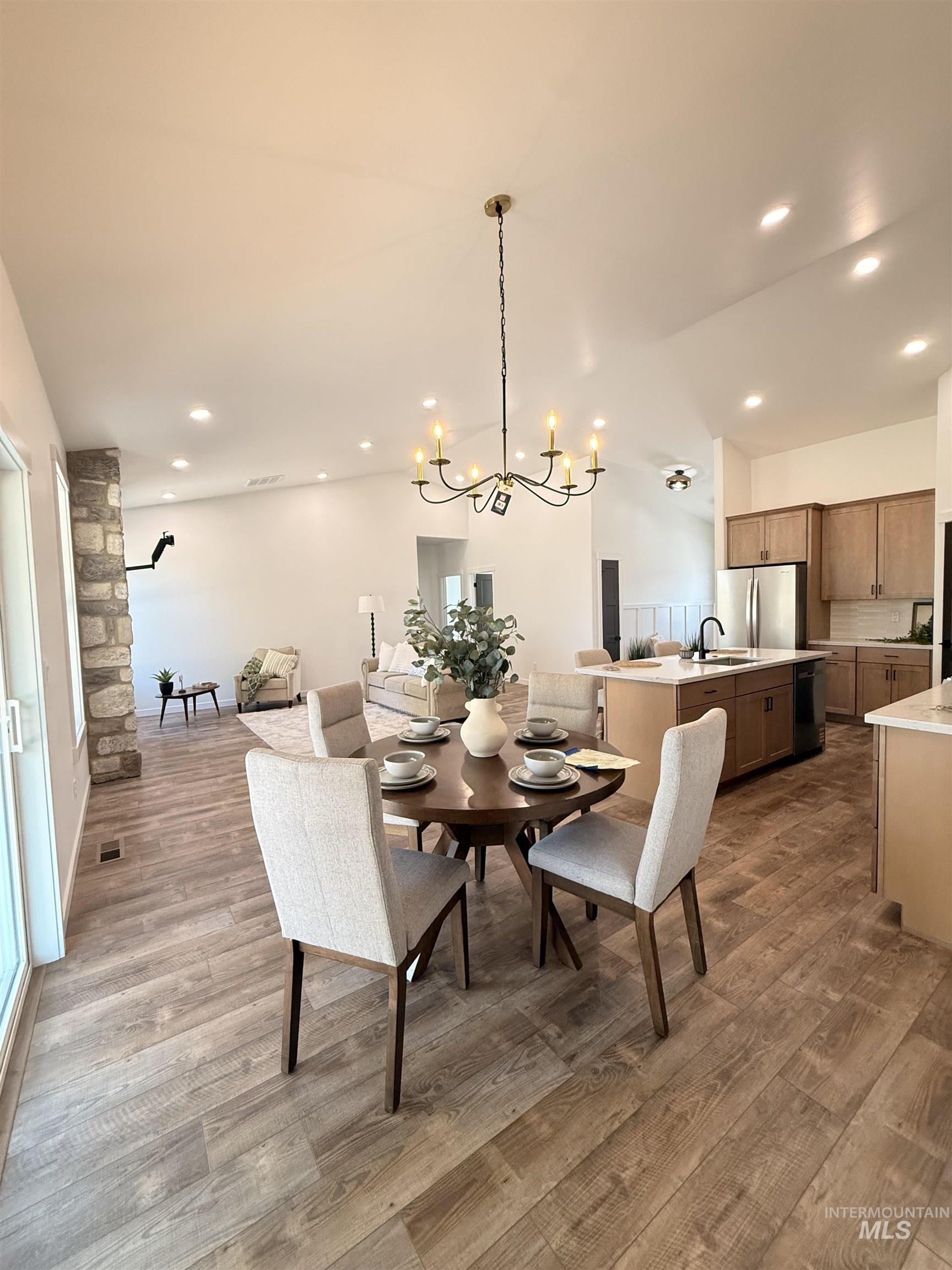 1220 Bronze Rupert, ID 83350 - Photo 13 of 30 Vaulted ceiling with recessed lighting and a chandelier, wood-finish flooring, and stone accent wall