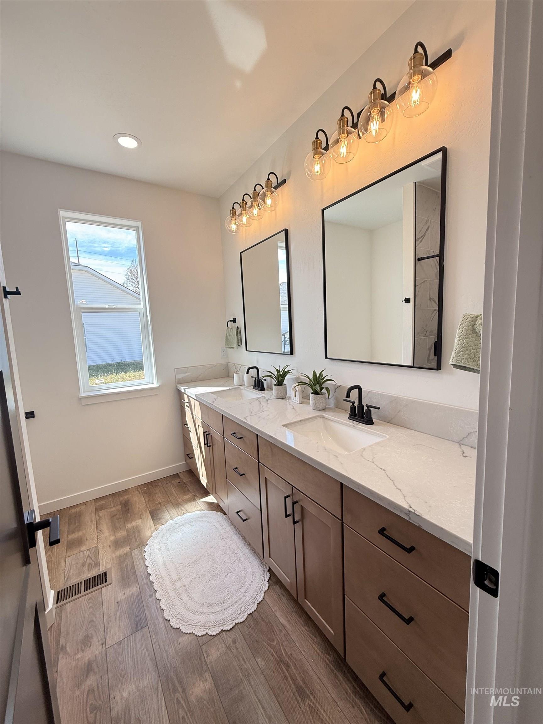 1220 Bronze Rupert, ID 83350 - Photo 19 of 30 Dual vanity featuring light wood-finish cabinetry, white countertops, and integrated rectangular sinks