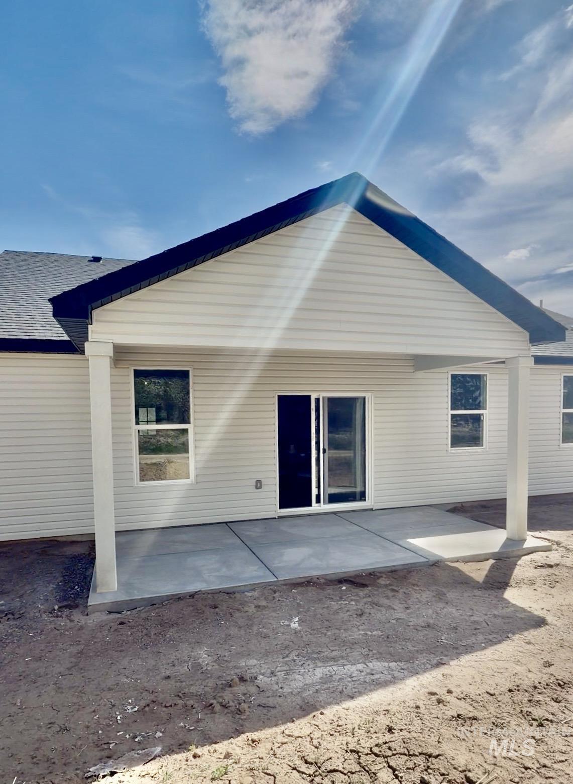 1220 Bronze Rupert, ID 83350 - Photo 30 of 30 Exterior patio featuring a concrete surface, covered porch, two white support columns, white horizontal siding, and a sliding glass door