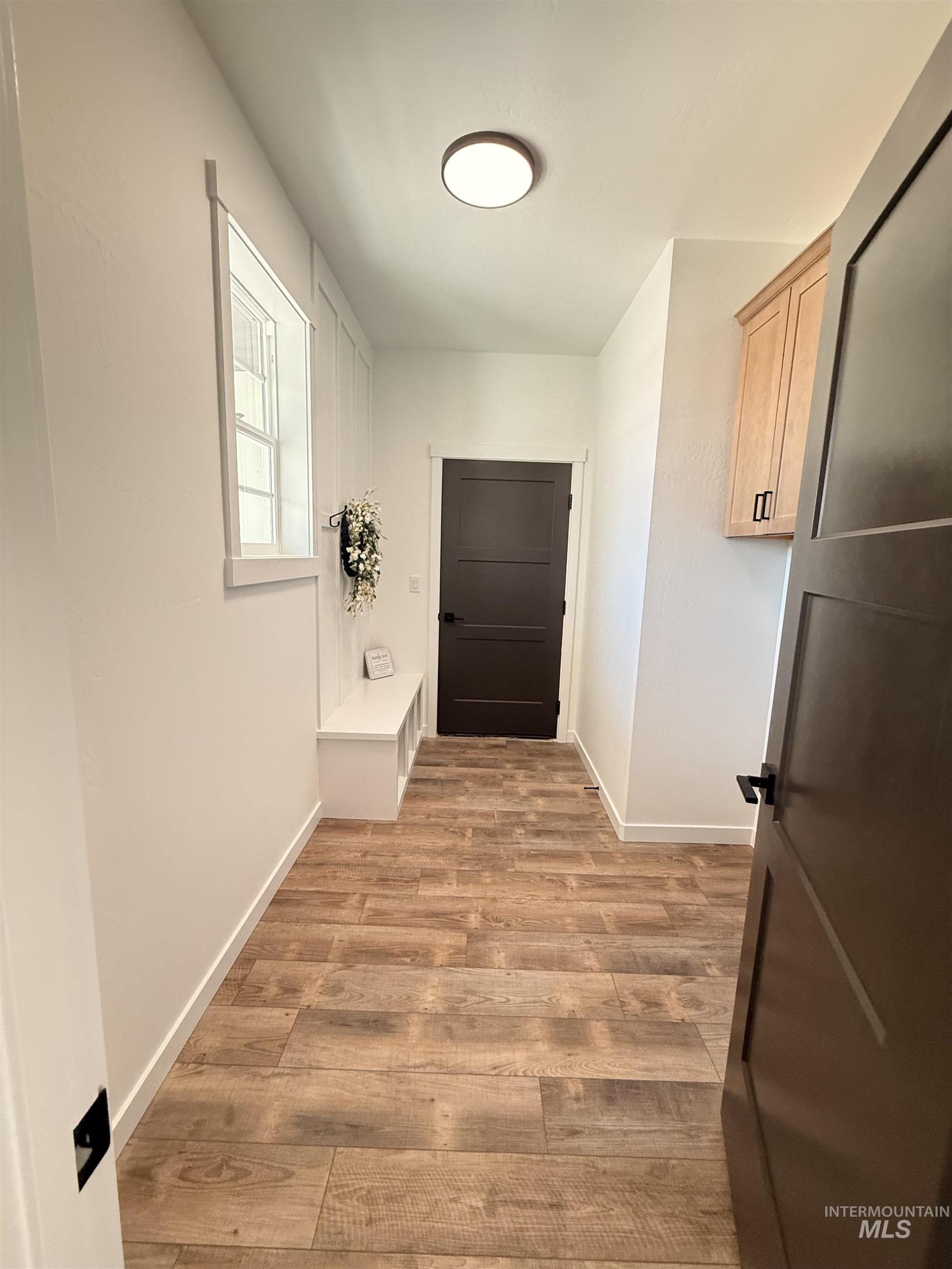 1220 Bronze Rupert, ID 83350 - Photo 4 of 30 Entryway featuring wood-finish flooring, a built-in bench with storage, and a window with white trim