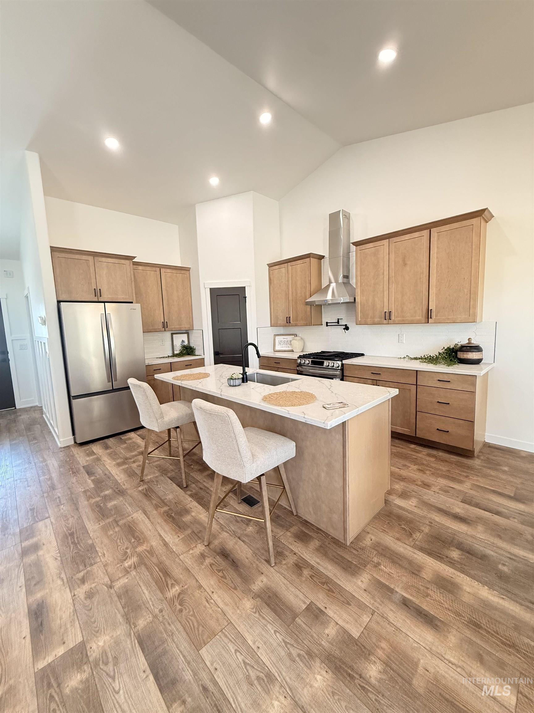 1220 Bronze Rupert, ID 83350 - Photo 9 of 30 Open-concept kitchen featuring wood-finish flooring, a vaulted ceiling, recessed lighting, and light wood cabinetry