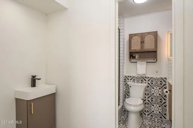 a bathroom with a toilet a sink and mirror