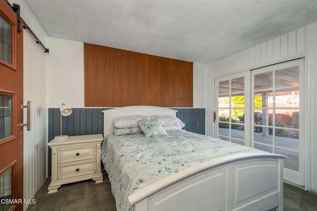 a bedroom with a bed and a large window