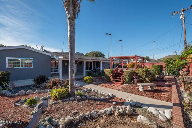 a view of a patio with table and chairs under an umbrella