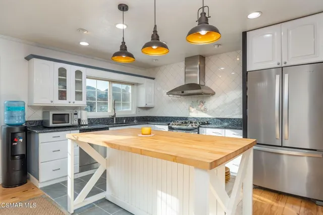 a kitchen with stainless steel appliances granite countertop a stove a refrigerator and a microwave